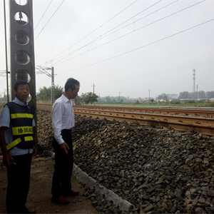 铁路护路巡逻队员巡查辖区铁路道口，检查铁路护栏完好情况。